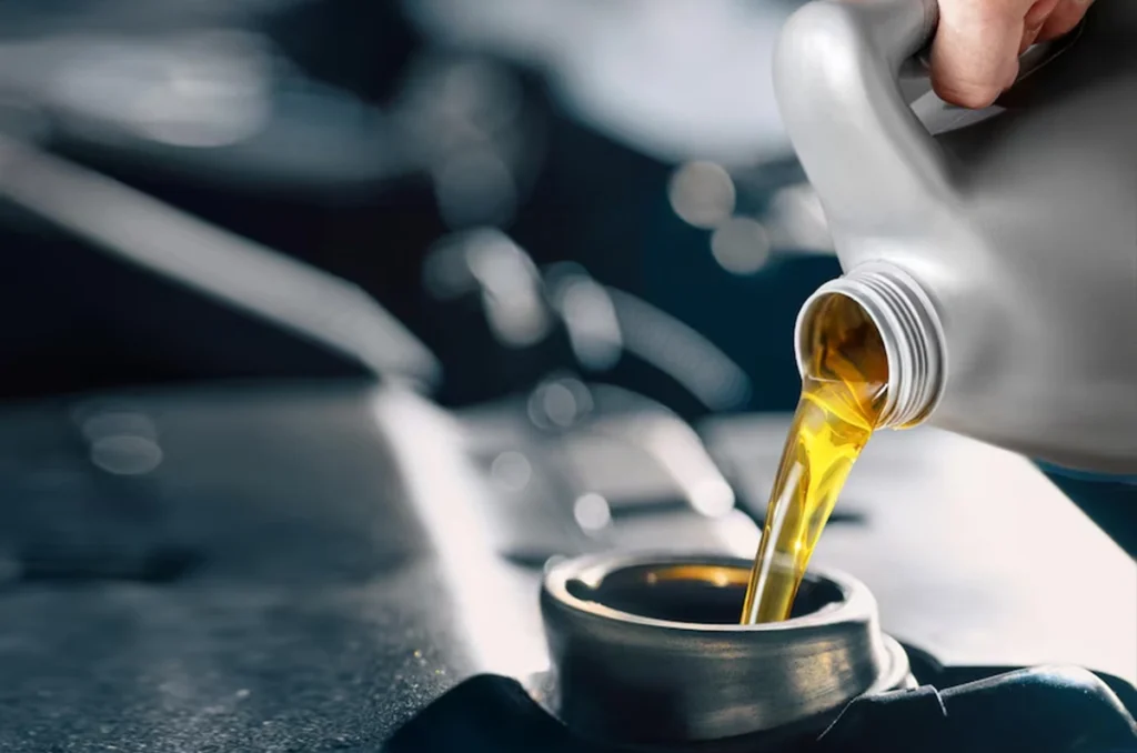 Fresh engine oil being added to a car engine, highlighting lubrication for performance.